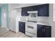 Kitchen features blue cabinets, white appliances and white countertops at 4031 Eagle Nest Dr, Hernando Beach, FL 34607