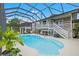 Inviting screened-in pool area features a uniquely shaped pool and staircase access to the home's second level at 4031 Eagle Nest Dr, Hernando Beach, FL 34607