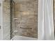 Tiled shower featuring a handrail, shower head, and a partially visible shower curtain offering functionality and style at 4031 Eagle Nest Dr, Hernando Beach, FL 34607