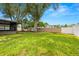 Large backyard with grassy area and mature trees at 15019 Southfork Dr, Tampa, FL 33624