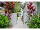 Landscaped side yard with a gate and lush plants, providing privacy and charm at 1411 E Powhatan Ave, Tampa, FL 33604