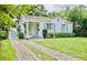 Charming bungalow with a brick driveway, lush lawn, and inviting front porch at 1411 E Powhatan Ave, Tampa, FL 33604
