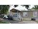 Mobile home with covered porch, golf cart, and landscaping at 6404 Land O Lakes Blvd., Land O Lakes, FL 34638