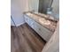 Bathroom featuring dual sinks, granite countertops, and vinyl plank flooring at 18146 Beach Ranch Ter, Lakewood Ranch, FL 34211