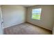 Neutral carpeted bedroom with a window allowing ample natural light at 18146 Beach Ranch Ter, Lakewood Ranch, FL 34211