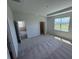 Bright primary bedroom with neutral carpet, tray ceiling, and a view of the green backyard at 18146 Beach Ranch Ter, Lakewood Ranch, FL 34211