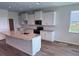 Bright kitchen featuring white cabinets, a granite island, and stainless steel appliances at 18146 Beach Ranch Ter, Lakewood Ranch, FL 34211