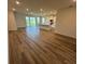 Open-concept floor plan with wood flooring leading to the kitchen and sliding glass doors to the outdoor space at 18204 Beach Ranch Ter, Lakewood Ranch, FL 34211
