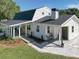 White farmhouse with a wraparound porch, stone walkway, and manicured lawn at 4608 Holbrook Rd, Plant City, FL 33565