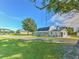 White farmhouse with a large yard, a tree swing, and outbuildings at 4608 Holbrook Rd, Plant City, FL 33565