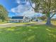 White farmhouse on a spacious lot with a tree swing and outbuildings at 4608 Holbrook Rd, Plant City, FL 33565