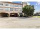 Exterior of a 3-story building with arched parking entrance, landscaping, and brick pavement at 2331 W Horatio St # 610, Tampa, FL 33609