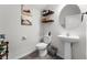 Cozy half bathroom with a modern vanity, toilet, and decorative shelves at 10744 Hawks Landing Dr, Land O Lakes, FL 34638