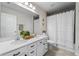 Bathroom with double vanity, white cabinets, and a shower with tub at 10744 Hawks Landing Dr, Land O Lakes, FL 34638