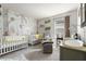 Light and airy Bedroom room design featuring whimsical wallpaper, two cribs, and a comfortable seating area at 10744 Hawks Landing Dr, Land O Lakes, FL 34638