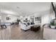Open-concept living room with wood floors, modern decor, and seamless flow to the kitchen and dining area at 10744 Hawks Landing Dr, Land O Lakes, FL 34638