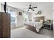 Light-filled bedroom features a ceiling fan, carpet flooring, and two windows with charming white sheer curtains at 10744 Hawks Landing Dr, Land O Lakes, FL 34638
