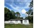 Newly renovated home with gray roof, white exterior, and landscaped yard at 4830 Capron St, New Port Richey, FL 34653