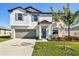 Two-story house with gray garage door and landscaped lawn at 3172 Lytton Hall Dr, Zephyrhills, FL 33540