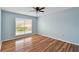 Bright bedroom with wood-look floors, ceiling fan, and large window at 9481 Highland Oak Dr # 1615, Tampa, FL 33647