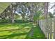 Landscaped backyard with grassy area and white picket fence at 17721 Ridgeway Point Pl, Tampa, FL 33647