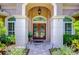 Elegant entryway with double doors, arched entry, and stone pathway at 10641 Echo Lake Dr, Odessa, FL 33556