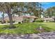 Single-story home with lush green lawn and mature shade tree at 1015 Radison Lake Ct # 65, Sun City Center, FL 33573