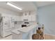 Galley style kitchen with breakfast bar and white cabinets at 1015 Radison Lake Ct # 65, Sun City Center, FL 33573