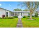 Charming single-story home features a well-maintained lawn, mature landscaping, and a welcoming entrance at 1305 Whitebridge Dr # A, Palm Harbor, FL 34684