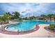 Bright community pool featuring clear blue water, a raised jacuzzi, and surrounding foliage under partly cloudy sky at 13292 Sea Bridge Dr, Hudson, FL 34669