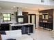 Modern kitchen with dark cabinetry, quartz countertops, and stainless steel appliances at 26638 Green Willow Run, Wesley Chapel, FL 33544