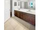 Double vanity bathroom with dark brown cabinets and tile flooring at 13292 Sea Bridge Dr, Hudson, FL 34669