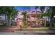 Two-story home with a pink facade, double garage and lush landscaping at 825 Islebay Dr, Apollo Beach, FL 33572