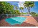 Inviting pool area with brick deck and lush tropical landscaping at 825 Islebay Dr, Apollo Beach, FL 33572