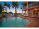 Inviting pool area with brick deck, and waterfront views at sunset at 825 Islebay Dr, Apollo Beach, FL 33572