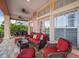 Relaxing covered patio furnished with wicker seating and red cushions at 825 Islebay Dr, Apollo Beach, FL 33572