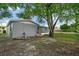 Spacious backyard with large tree and screened patio at 1332 Maybury Dr, Holiday, FL 34691