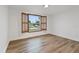 Bedroom with wood-look floors and window with shutters at 1332 Maybury Dr, Holiday, FL 34691