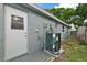 Exterior view of home with AC unit and backyard at 1332 Maybury Dr, Holiday, FL 34691