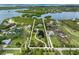 Stunning aerial view of waterfront property featuring lush landscaping, a serene pond, and expansive lawns, perfect for luxurious living at 1215 Bayshore Dr, Terra Ceia, FL 34250