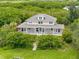 Beautiful home surrounded by lush trees, showcasing curb appeal and serene setting at 1215 Bayshore Dr, Terra Ceia, FL 34250