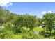 Lush backyard view of the foliage, picket fence, and bird bath of this home at 1215 Bayshore Dr, Terra Ceia, FL 34250
