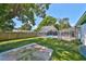 Backyard showcasing a screened pool, patio, and lush green lawn at 3908 W Wallace Ave, Tampa, FL 33611