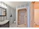 Bathroom with patterned wallpaper, pedestal sink, shower stall, and toilet at 3908 W Wallace Ave, Tampa, FL 33611