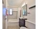 Clean bathroom featuring a shower-tub combo, decorative tiles, and ample vanity space at 3908 W Wallace Ave, Tampa, FL 33611