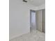 Hallway featuring neutral walls, gray tile floors, and a closet with open doors at 3908 W Wallace Ave, Tampa, FL 33611