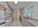 Bright kitchen with gray cabinets, granite countertops, and a view to the outside at 3908 W Wallace Ave, Tampa, FL 33611