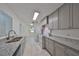 Bright kitchen featuring gray cabinets, granite countertops, and stainless steel appliances at 3908 W Wallace Ave, Tampa, FL 33611