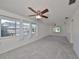 Spacious living room with carpet, fan, and large windows with ample natural light at 3908 W Wallace Ave, Tampa, FL 33611