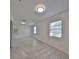 Living Room featuring neutral walls, gray tile floors, and plenty of windows at 3908 W Wallace Ave, Tampa, FL 33611
